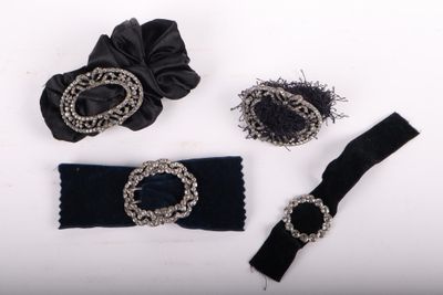 three pieces of black and silver jewelry on a white surface