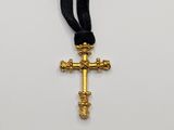 a close up of a cross on a black ribbon on a white surface