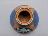 a blue and orange vase sitting on a white surface
