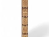 an old book with a brown cover sitting on top of a white surface