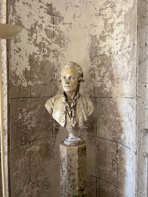 un buste d'homme assis sur un socle dans une pièce