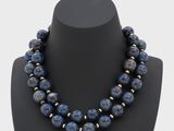 a necklace made of lapis and gold beads on a mannequin