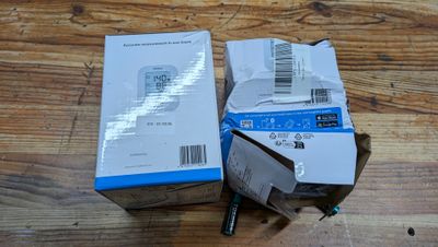 deux boîtes contenant des appareils électroniques posées sur une table en bois
