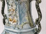 a blue and white vase with a handle on a table