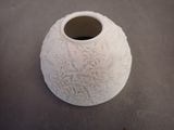 a white vase that is sitting on a table