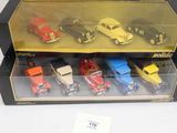 six petites voitures dans une vitrine posée sur une table