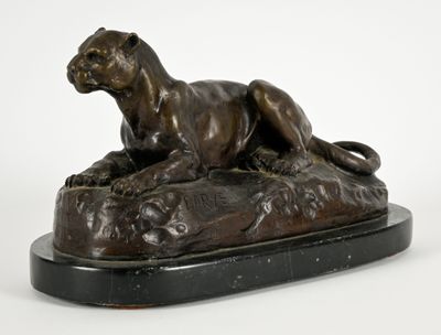 une image représentant une statue en bronze d'un lion posé sur un rocher