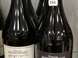 trois bouteilles de vin posées sur une table en verre