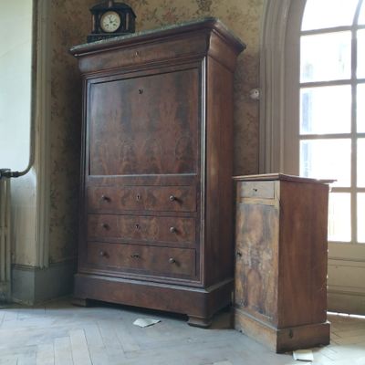 une commode et un meuble de rangement dans une pièce, sur lequel se trouve une horloge