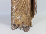 statue of a man in a robe holding a sword and a shield