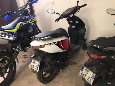 Plusieurs motos sont garées en rang dans un garage.