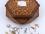 un gros plan sur une boîte en bois contenant un assortiment de bijoux