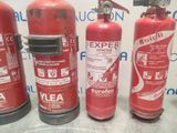four fire extinguisors are lined up on a table