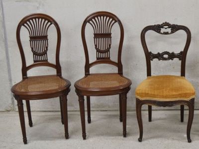 trois chaises en bois placées les unes à côté des autres sur un sol en béton