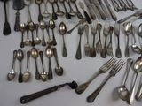 many spoons and forks laid out on the table