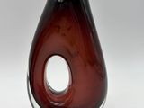 a brown glass vase with a hole in it