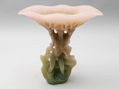 un petit vase orné d'une fleur, posé sur une surface blanche