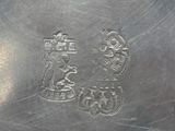 a silver plate with a design on the side of it