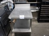 une table en acier inoxydable sur laquelle est posée une étiquette de prix, dans une cuisine