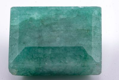 gros plan d'une pierre d'émeraude verte sur une surface blanche