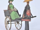 a figurine of a woman and a man in a carriage