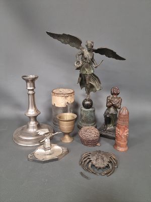 une statue d'ange posée sur une table, à côté d'autres objets