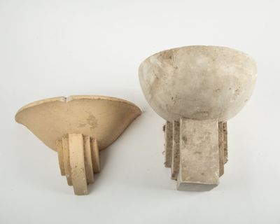 two pieces of pottery sitting on a white surface