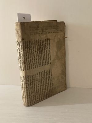 un vieux livre posé sur une table, d'où dépasse un bout de papier