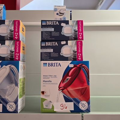 trois boîtes de biberons sur une étagère dans un magasin