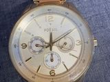 an image of a close up of a wrist watch on a blue cloth