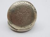 a small silver pocket watch on a white surface