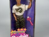 une poupée Barbie aux cheveux blonds, vêtue d'un t-shirt blanc, dans une boîte rose