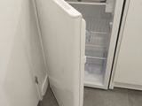 an open refrigerator in the corner of a kitchen
