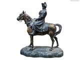 une statue représentant un homme à cheval sur un rocher