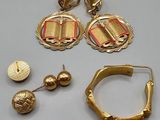 two pairs of gold earrings and a pair of gold hoop earrings