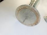 a metal object sitting on a white surface next to a metal object
