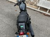 a black motorcycle parked in front of a stone wall