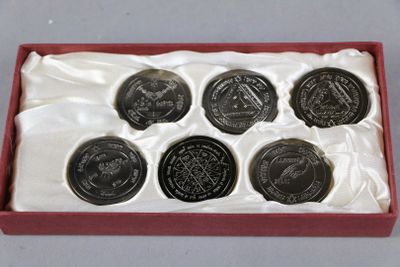 les six pièces se trouvent dans une boîte rouge posée sur un tissu blanc