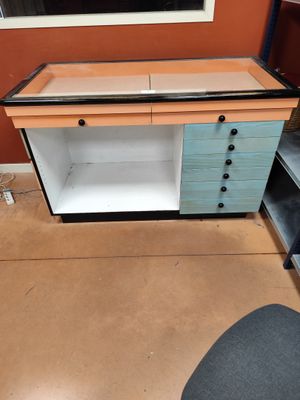 une image représentant un bureau avec un plateau en verre et des tiroirs