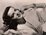 black and white photograph of a woman laying on a couch with her arm resting on her chest