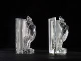 two clear glass figurines sitting on top of a black table