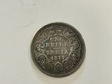 a silver coin on a white surface with a white background
