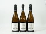 trois bouteilles de vin posées les unes à côté des autres sur une surface blanche