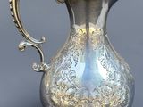 une cruche en argent munie d'une anse, sur fond gris