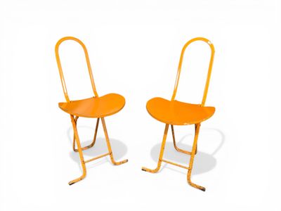 pair of orange plastic folding chairs against a white background