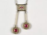 silver necklace with red stones on a white background