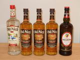 quatre bouteilles d'alcool sont alignées sur une table en bois