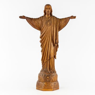 wooden statue of jesus with open arms on a white background