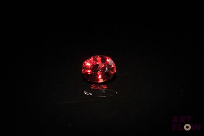 a close up of a red diamond on a black surface