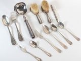 beaucoup de cuillères, de fourchettes et de brosses sur la table